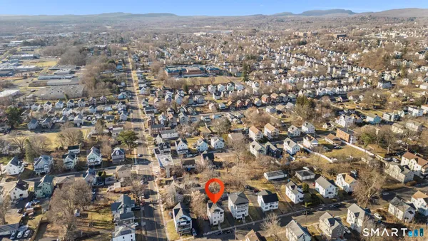 an aerial view of house with yard and mountain view in back