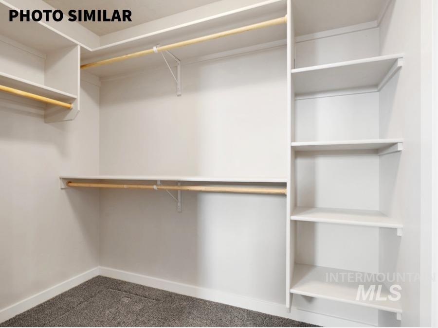 925 Twilight Weiser, ID 83672 - Photo 19 of 31 Walk-in closet featuring white built-in shelving, multiple hanging rods, and gray carpet flooring
