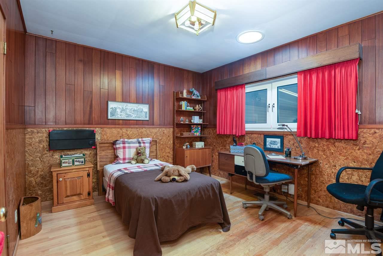 1270 Tacoma Way Reno, NV 89509 - Photo 13 of 24 a bedroom with a bed a desk and chair with a bookshelf
