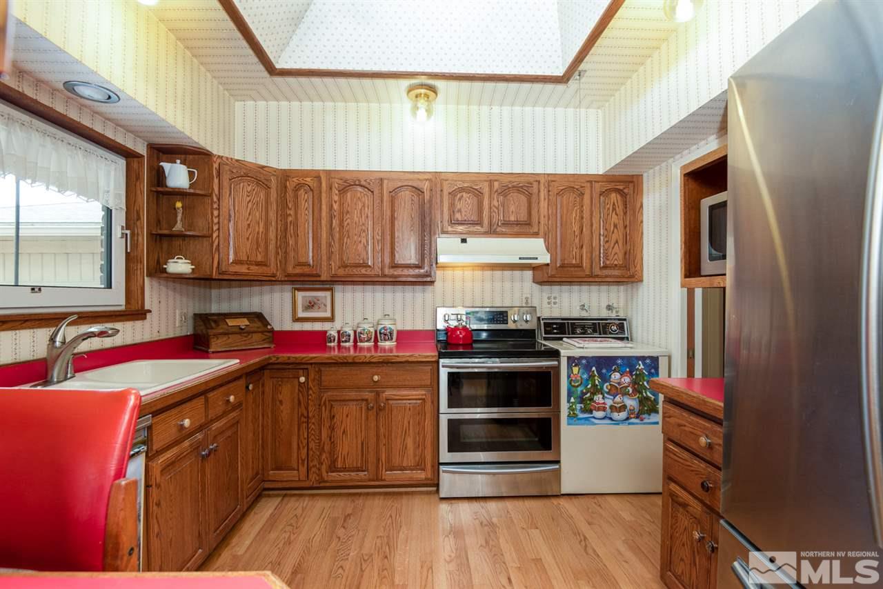 1270 Tacoma Way Reno, NV 89509 - Photo 8 of 24 a kitchen with stainless steel appliances a stove a sink dishwasher and wooden cabinets with wooden floor