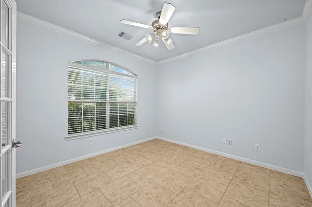 an empty room with windows and fireplace