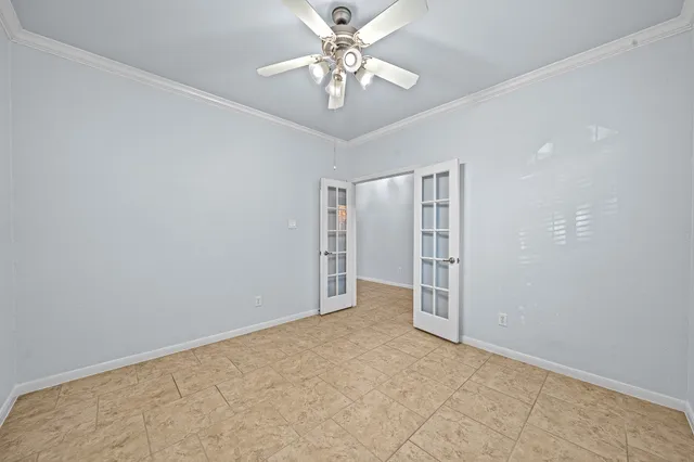 a view of a livingroom with a chandelier fan and windows