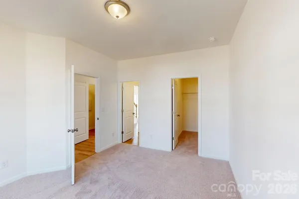a view of an empty room with closet and a window
