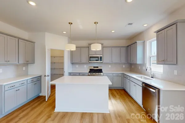 a kitchen with a sink a counter top space stainless steel appliances and cabinets