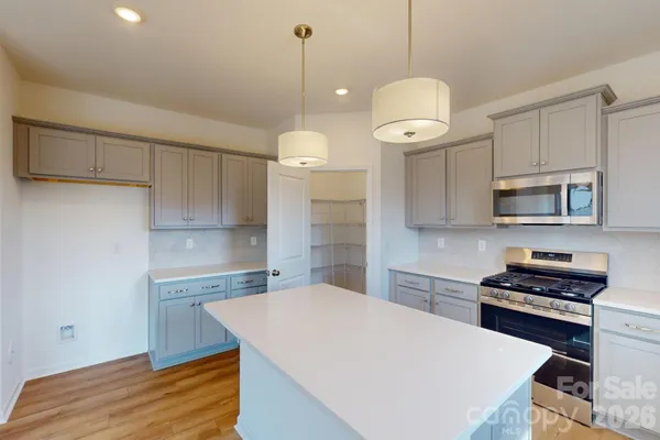 a kitchen with stainless steel appliances a stove a sink and white cabinets