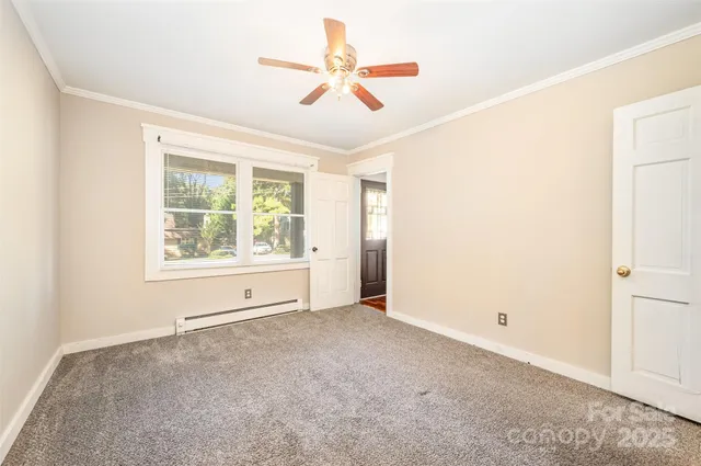 an empty room with ceiling fan and windows