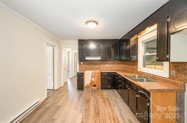 a view of a kitchen with a sink and wooden floor