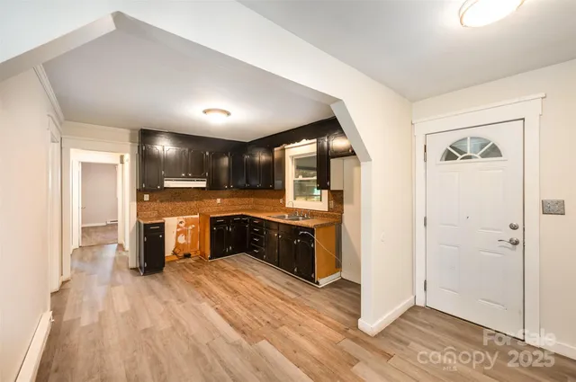 a kitchen with stainless steel appliances kitchen island granite countertop a refrigerator a sink and wooden cabinets