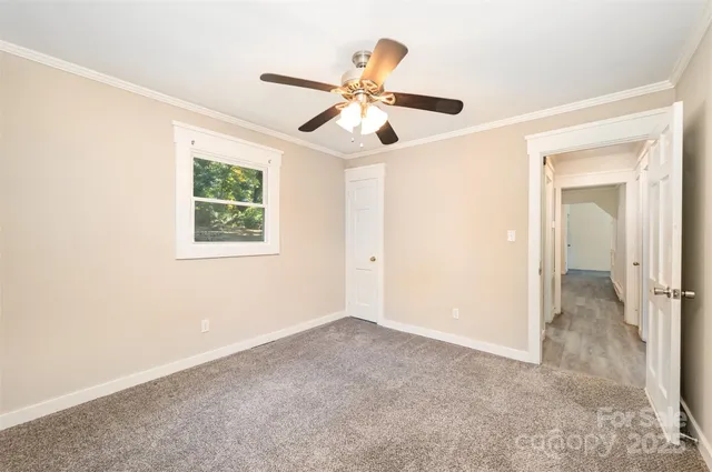 an empty room with fan and windows