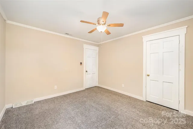 an empty room with a ceiling fan and wooden floor