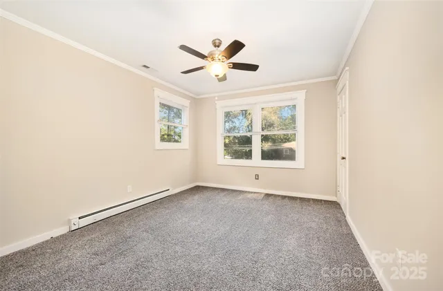 an empty room with window and ceiling fan