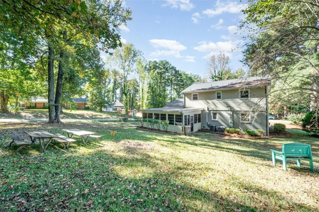 an outdoor view of house with swimming pool and green space