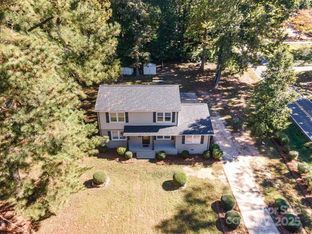 an aerial view of house with yard and mountain view in back