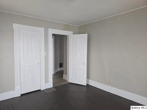 a view of an empty room with wooden floor