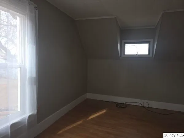 a view of a small space with wooden floor and a window
