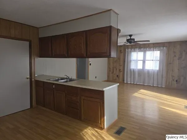 a kitchen with a sink cabinets and wooden floor