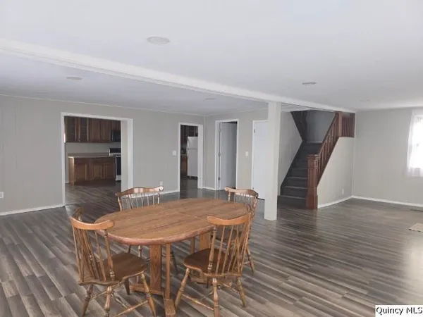 a dining room with furniture and wooden floor