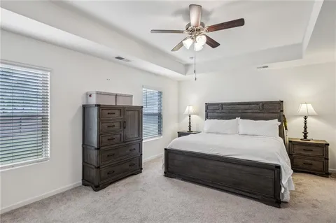 a bedroom with a bed a chandelier and a dresser