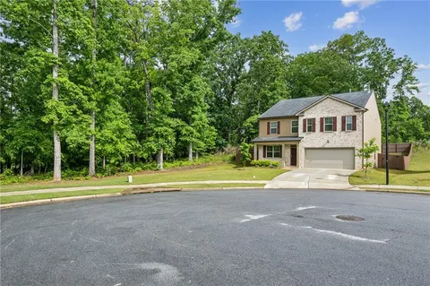 a view of a house with a big yard and large trees