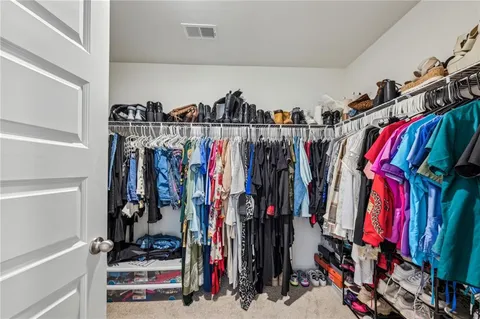 a view of walk in closet with clothes