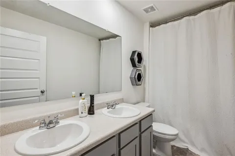 a bathroom with a sink toilet and mirror