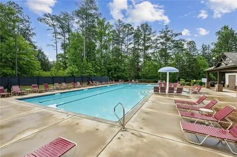 a view of a swimming pool with a table and chairs under an umbrella