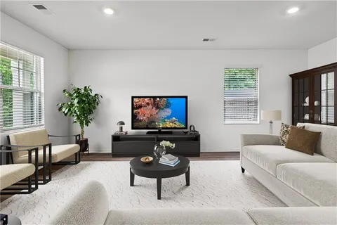 a living room with furniture a flat screen tv and a large window