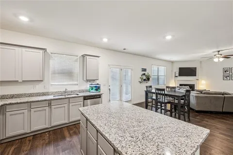 a kitchen with stainless steel appliances granite countertop sink stove top oven and cabinets