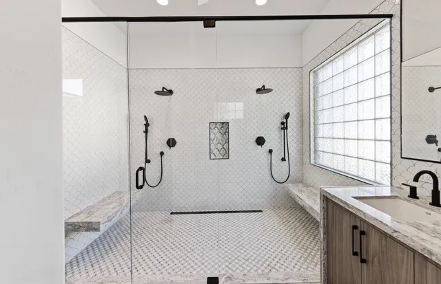 a bathroom with a granite countertop sink a toilet and shower