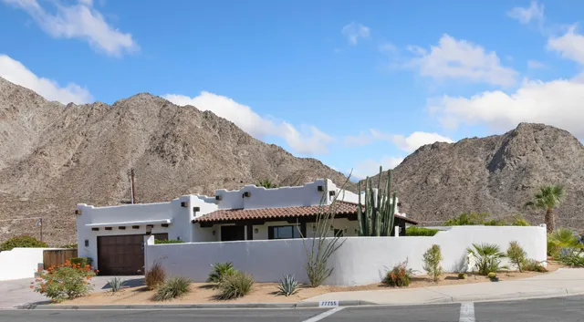 a view of a big house with a mountain in the background