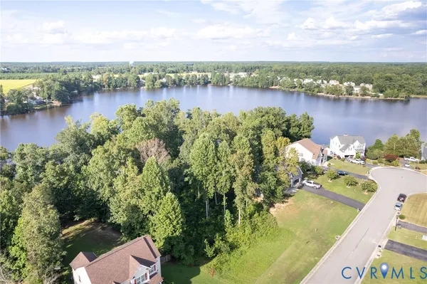 an aerial view of a residential houses with outdoor space and lake view