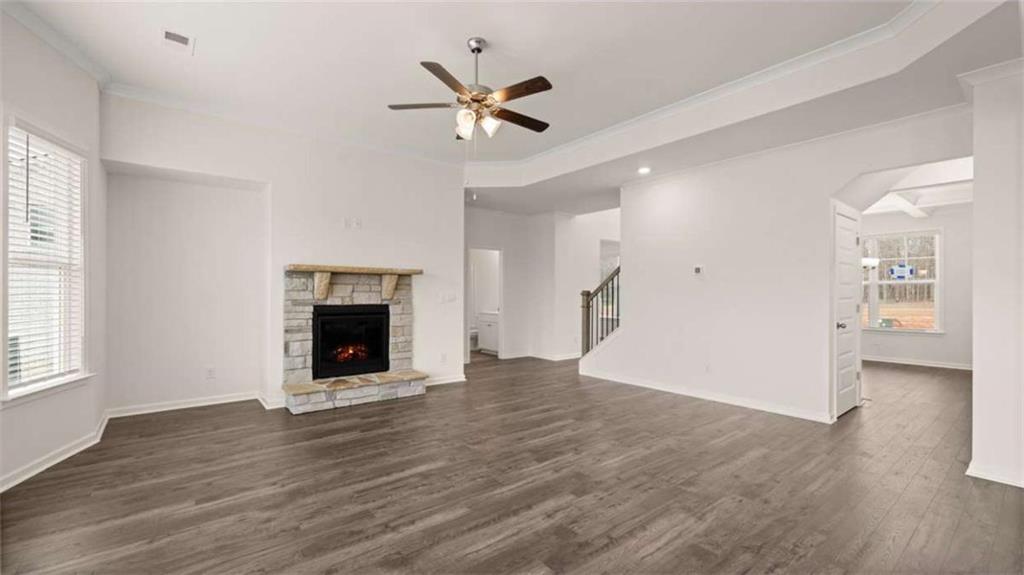 1776 Goodwin Drive Hampton, GA 30228 - Photo 18 of 43 an empty room with wooden floor a ceiling fan and windows