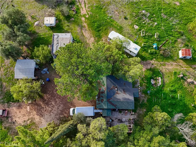 an aerial view of a house with a yard and tree s