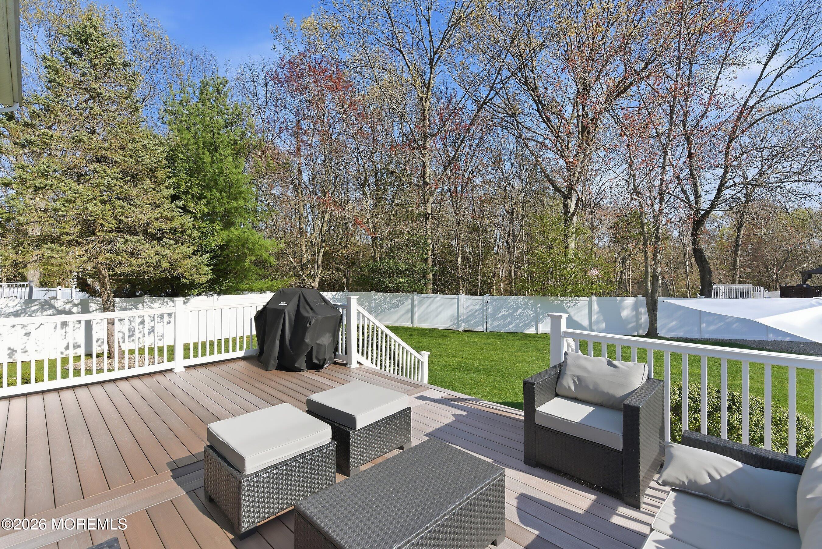 23 Paulette Lane Howell, NJ 07731 - Photo 5 of 35 a view of a deck with couches table and chairs and wooden fence