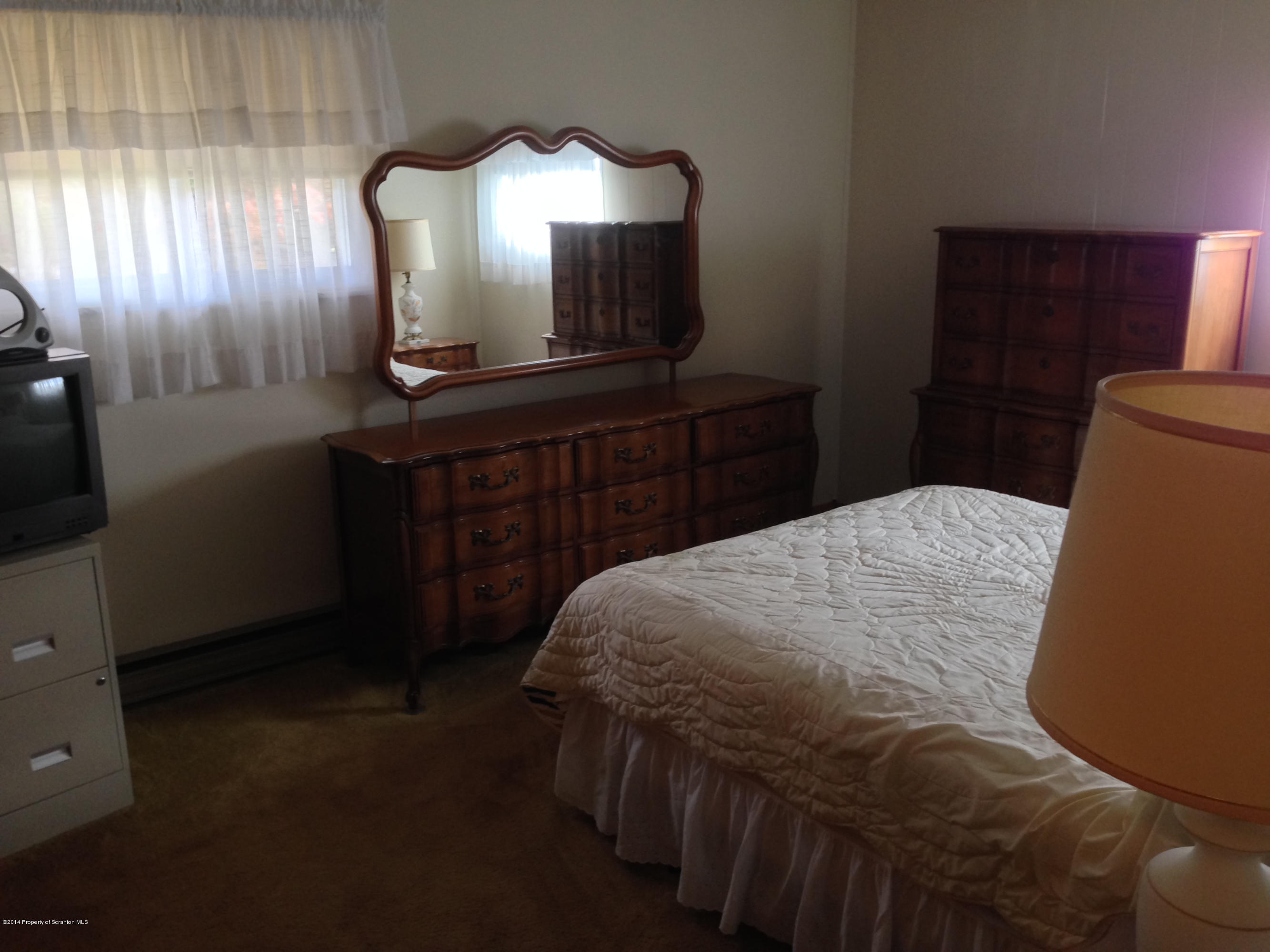 810 Lions Road Lake Ariel, PA 18436 - Photo 21 of 33 a bedroom with a bed and a mirror on dresser