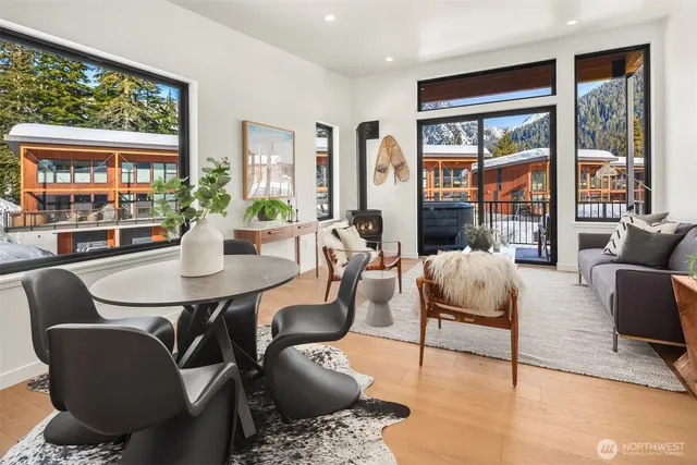 a living room with furniture large windows and wooden floor