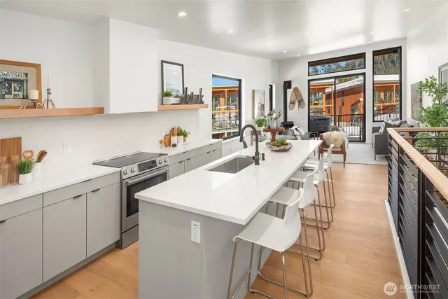 a kitchen with a sink a stove and chairs