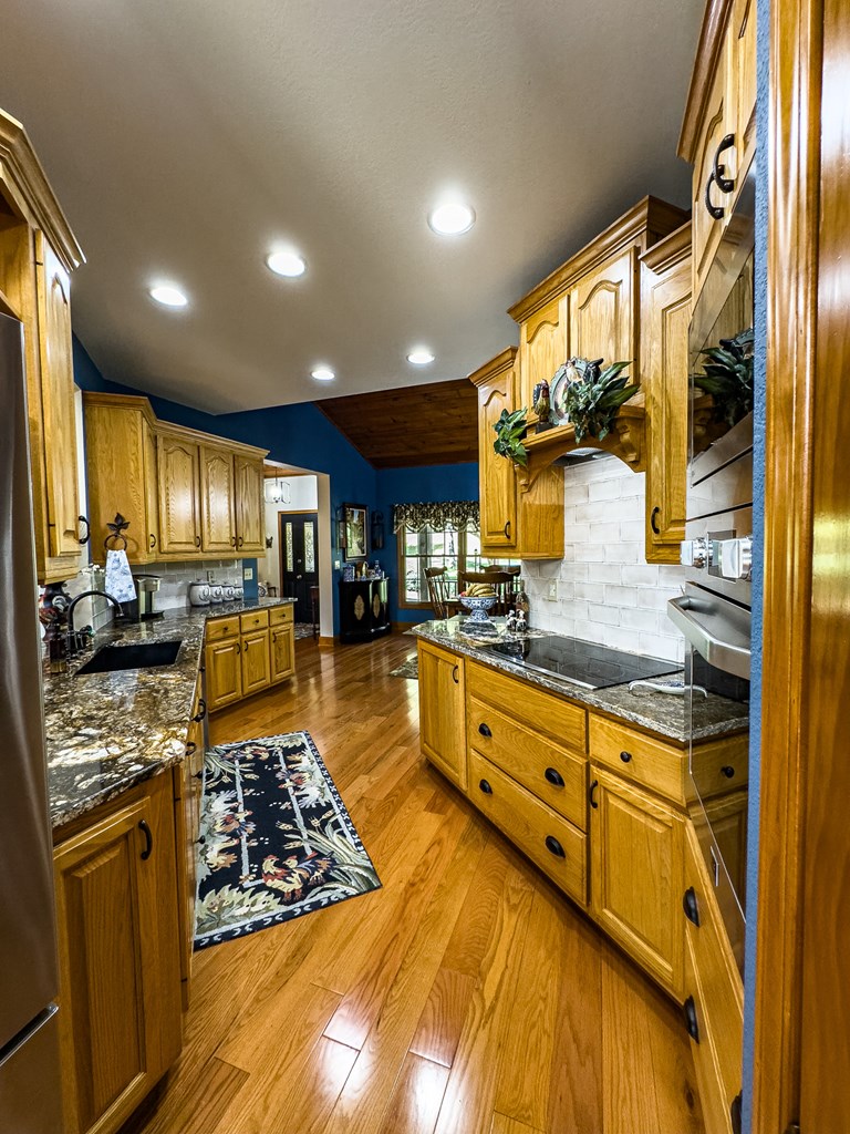 59 Cabin Run Lane Murphy, NC 28906 - Photo 33 of 82 a kitchen with stainless steel appliances granite countertop a stove top oven a sink dishwasher and cabinets with wooden floor