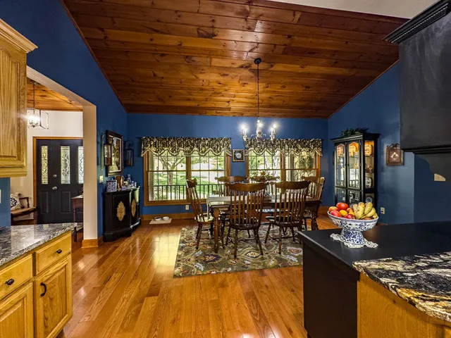 a view of a dining room with furniture a chandelier and wooden floor