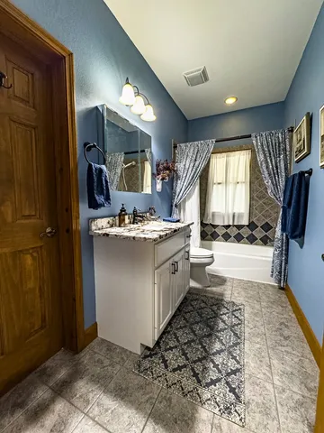 a large kitchen with stainless steel appliances kitchen island granite countertop a sink and wooden cabinets