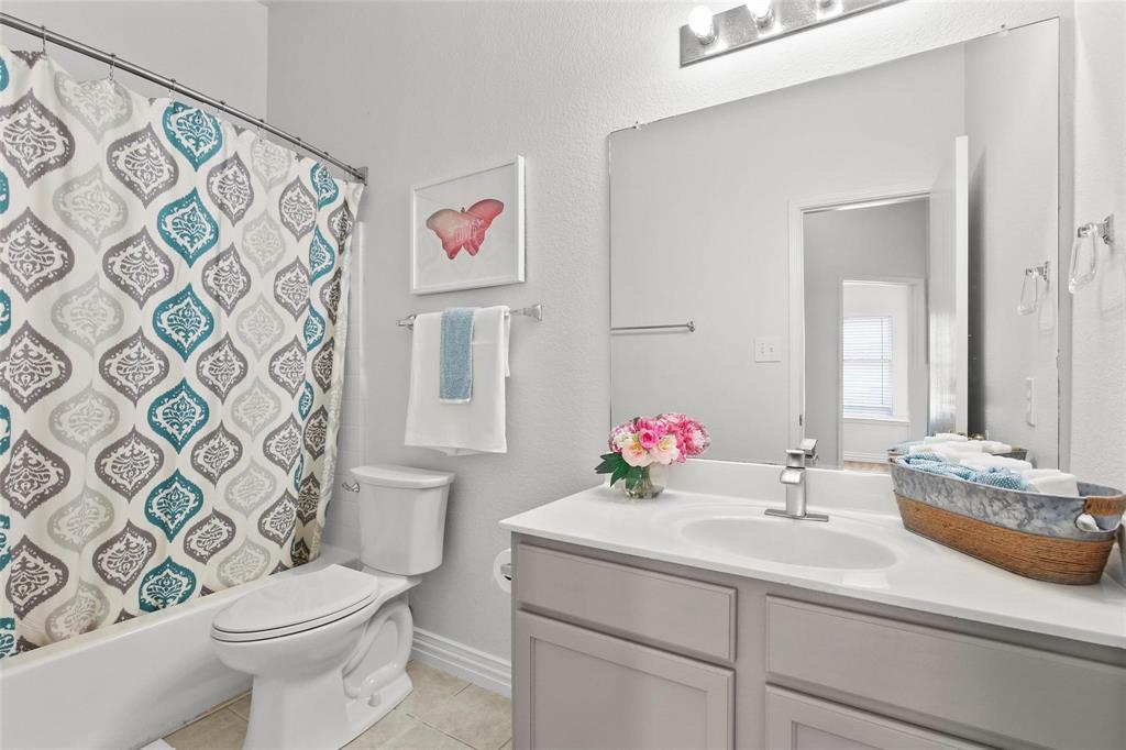 5961 Cheyenne Way Frisco, TX 75034 - Photo 27 of 33 Bathroom featuring a white bathtub with a shower curtain, a white toilet, and a vanity with a white countertop