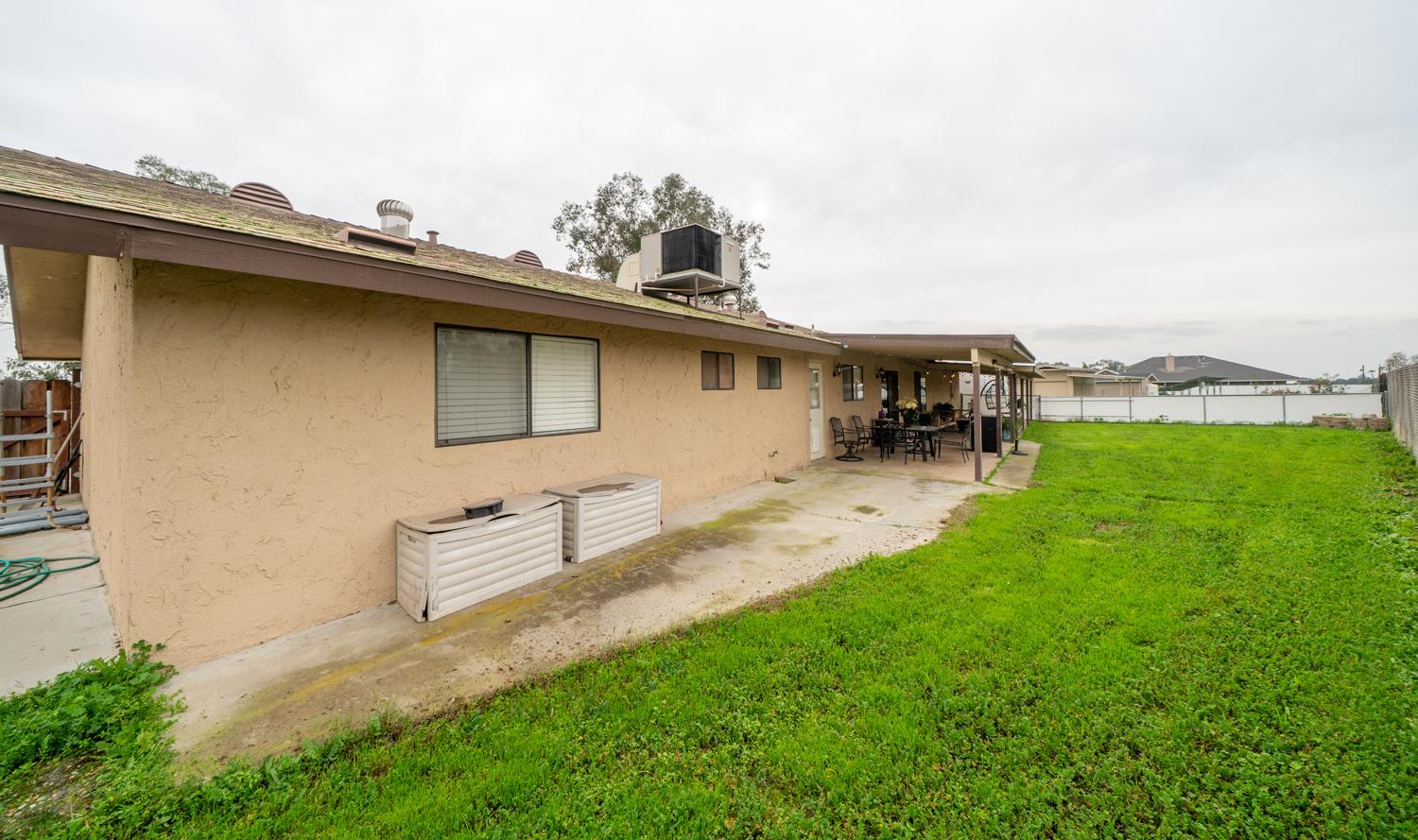 16026 Karen Road Madera, CA 93636 - Photo 16 of 38 a view of a patio with table and chairs with wooden fence