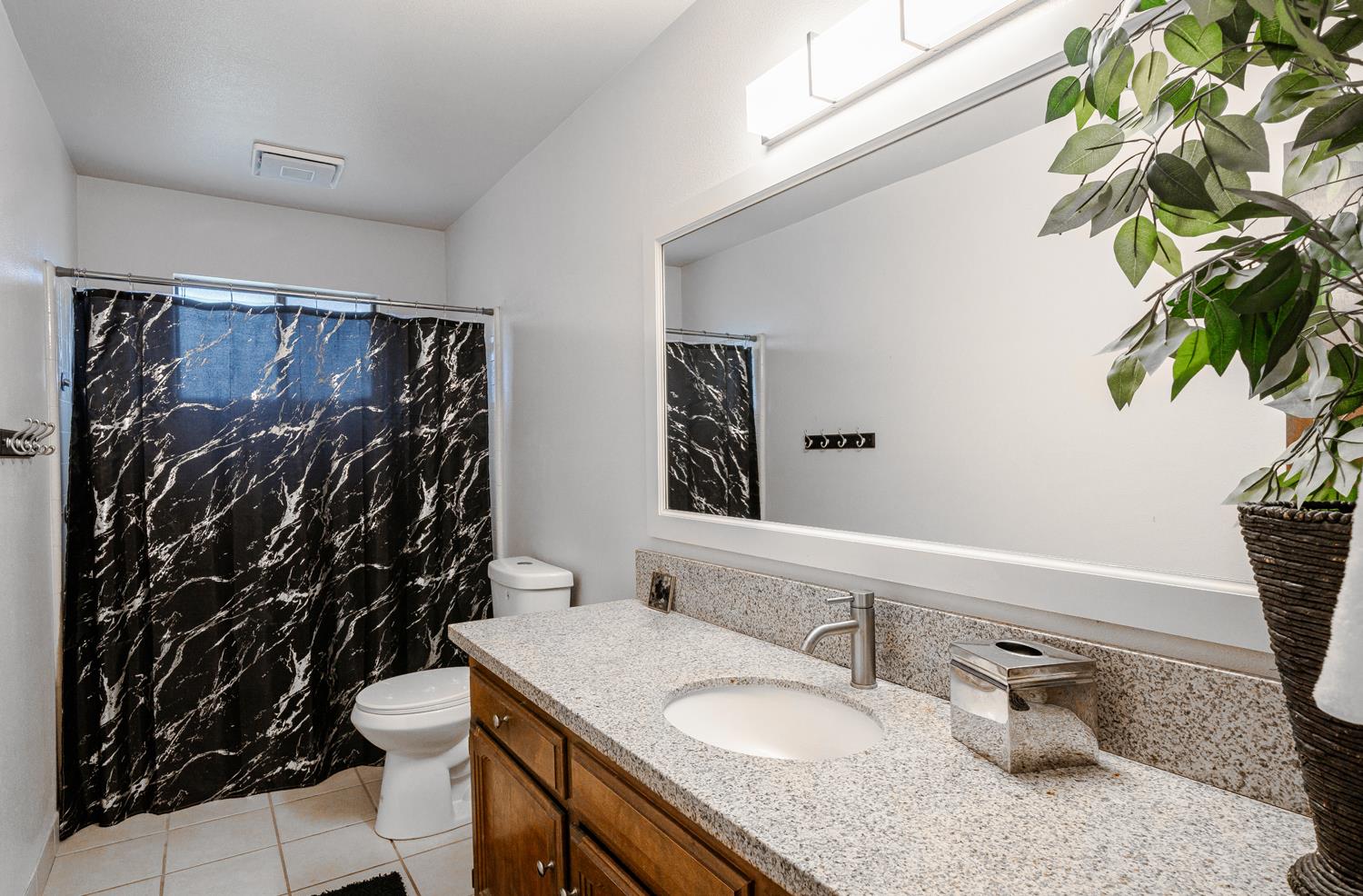 16026 Karen Road Madera, CA 93636 - Photo 30 of 38 a bathroom with a granite countertop sink and a mirror