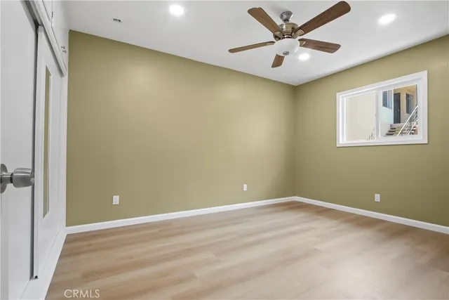 an empty room with a ceiling fan and a window