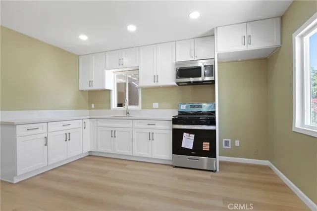 a kitchen with stainless steel appliances granite countertop a stove a sink and a microwave