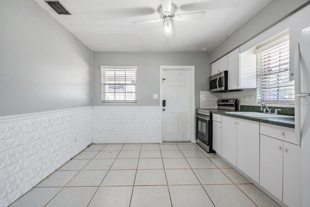 2709 West Abdella Street Tampa, FL 33607 - Photo 13 of 29 a kitchen with a stove a sink and a window