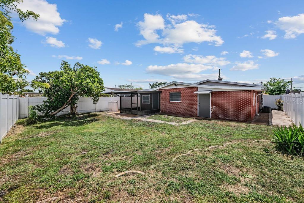 2709 West Abdella Street Tampa, FL 33607 - Photo 23 of 29 a view of a backyard with potted plants and a large tree