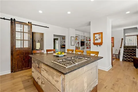 a view of a dining room and livingroom with furniture wooden floor a rug a glass table and chairs