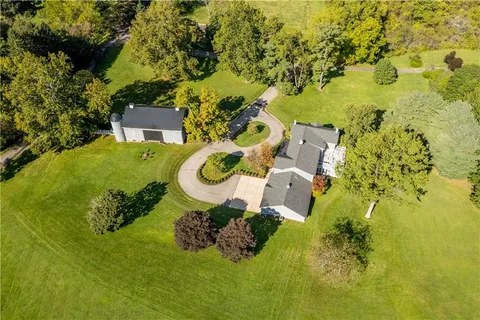 an aerial view of a house with swimming pool and garden