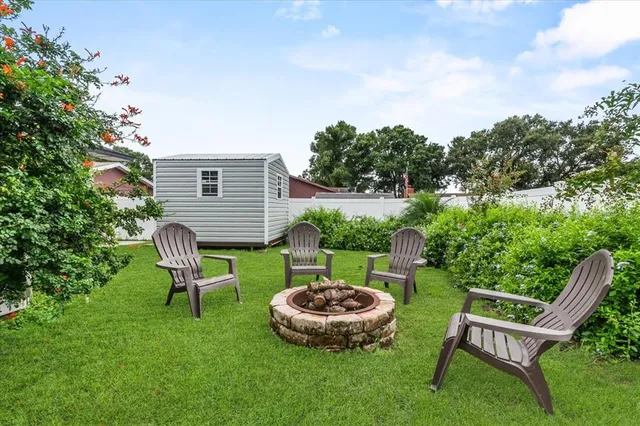 a view of a chair and table in backyard of the house